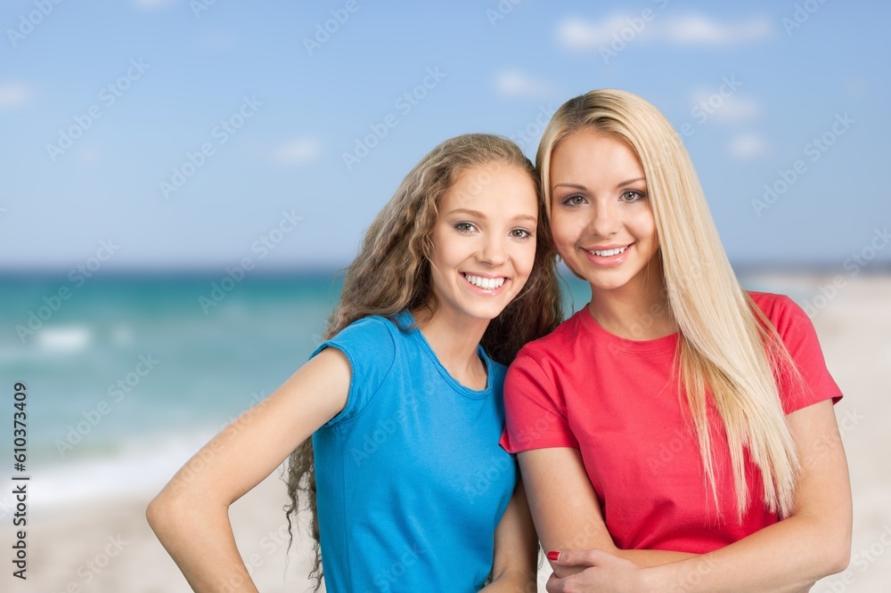 Couple of happy young female friends on beach