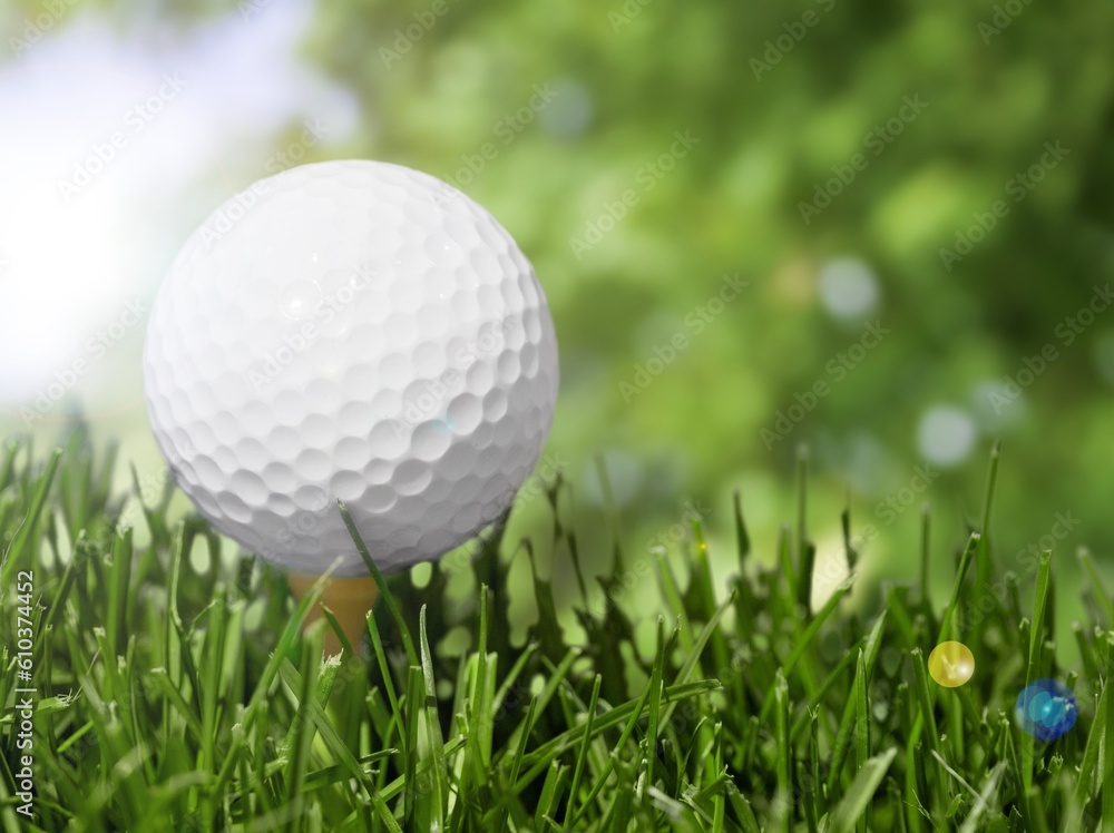 White golf ball on wooden tee with grass White golf ball on wooden tee with grass