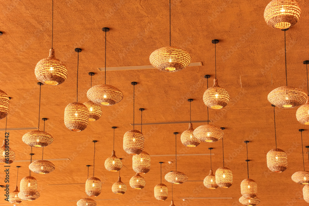 Obraz premium Stylish irregular straw like lamp shades on orange ceiling
