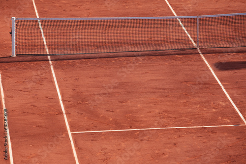 Fragment of clay tennis open court with footsteps. Grid and marking lines visible. Tennis net. Selective focus, design element.