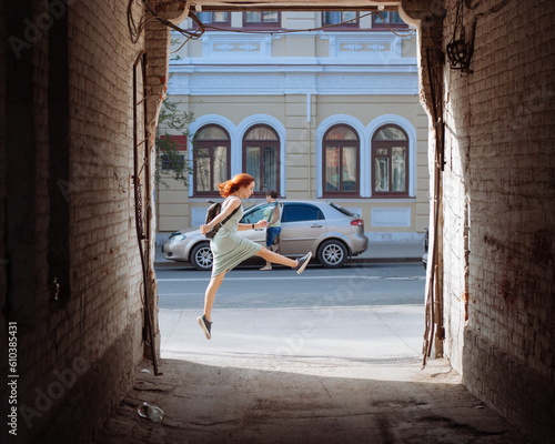 A girl in a jump on the background of an arch