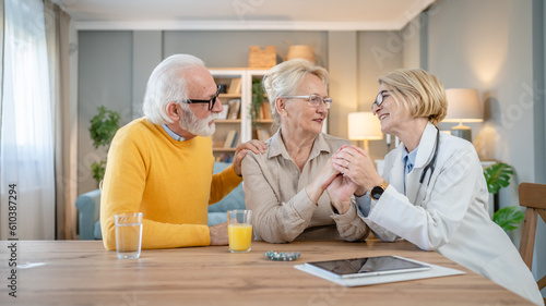 Home visit female doctor with senior man and woman couple at home talk