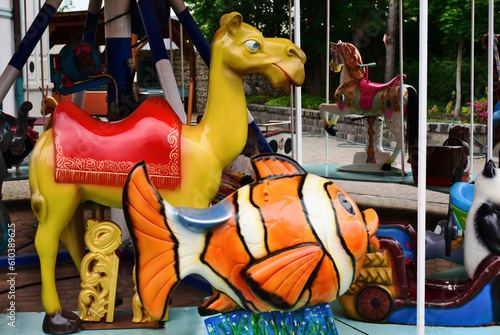 colorful carousel closeup detail in amusement park. vintage old, retro style. shiny animal figures. camel and Ocellaris Clownfish. fun, child play and entertainment concept. selective focus.
