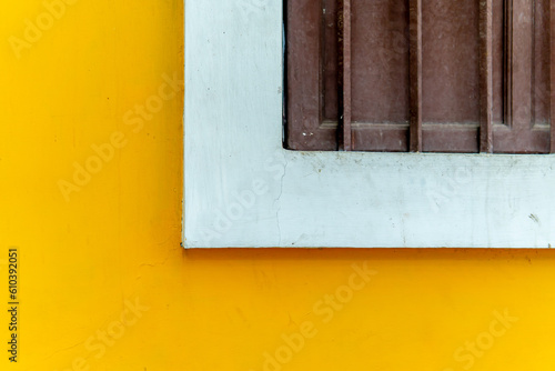 The yellow wall adorned with a half wooden window, gives the room a lively warmth and a welcoming atmosphere.