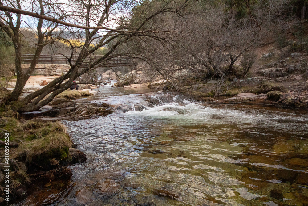 Obraz premium Impresionante paisaje de montañas rocosas en La Pedriza, con el río Manzanares serpenteando entre las formaciones de piedra. 