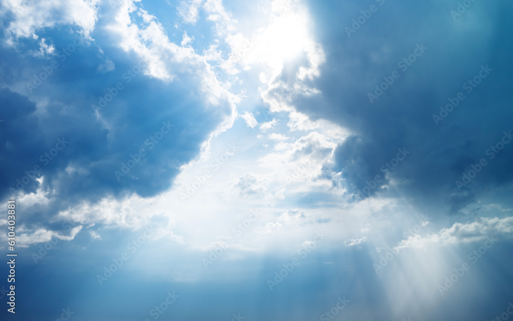 Blue dramatic sky background with clouds and sun rays coming out. Blue dramatic sky background with clouds and sun rays coming out.