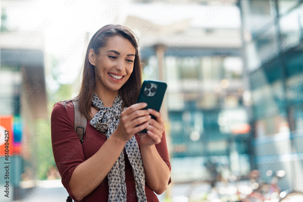 Portrait of beautiful woman using phone in street