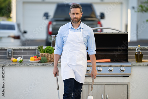 man grilling salmon fillet outdoor. man grilling salmon fillet at backyard. photo of man grilling
