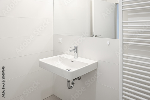 White sink and mirror on light wall in bathroom