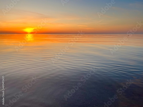Orange sea horizon  evening seascape background  natural colors  calm water surface reflection