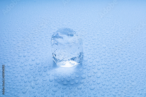 transparent Ice Cubes on a white table with reflection and water drops