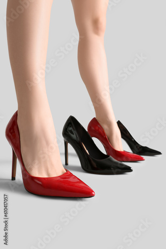 Female legs and stylish shoes on grey background