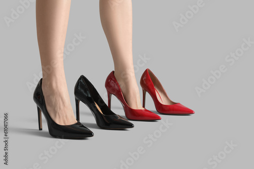 Female legs and stylish shoes on grey background