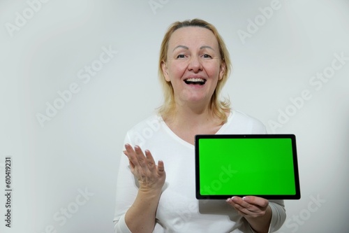 Cropped close up cutout portrait of smiling caucasian schoolgirl teenager child pupil student holding digital tablet showing blank screen with advert place mockup isolated