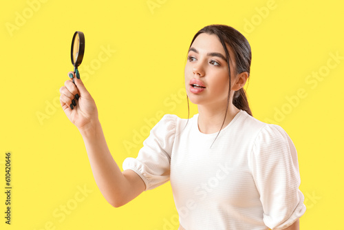 Young woman with magnifier ...