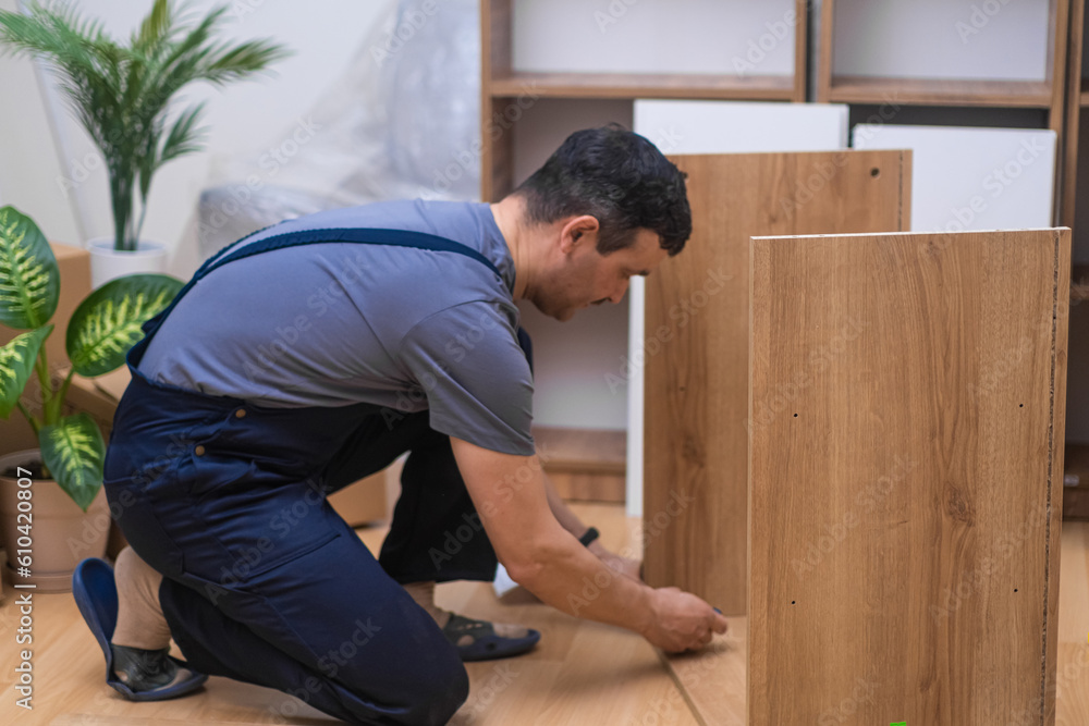 Furniture fixing and delivery company worker assembling wooden cabinet near decorative houseplant commercial carpentry business and apartment stylish interior design Furniture fixing and delivery company worker assembling wooden cabinet near decorative houseplant commercial carpentry business and apartment stylish interior design