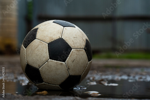 Soccer ball in puddles on the street