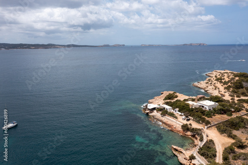 Aerial drone photo of a beach in the town of Sant Antoni de Portmany on the island of Ibiza Balearic Islands Spain showing the ocean front and Cala Alto de Porta beach in the summer time.