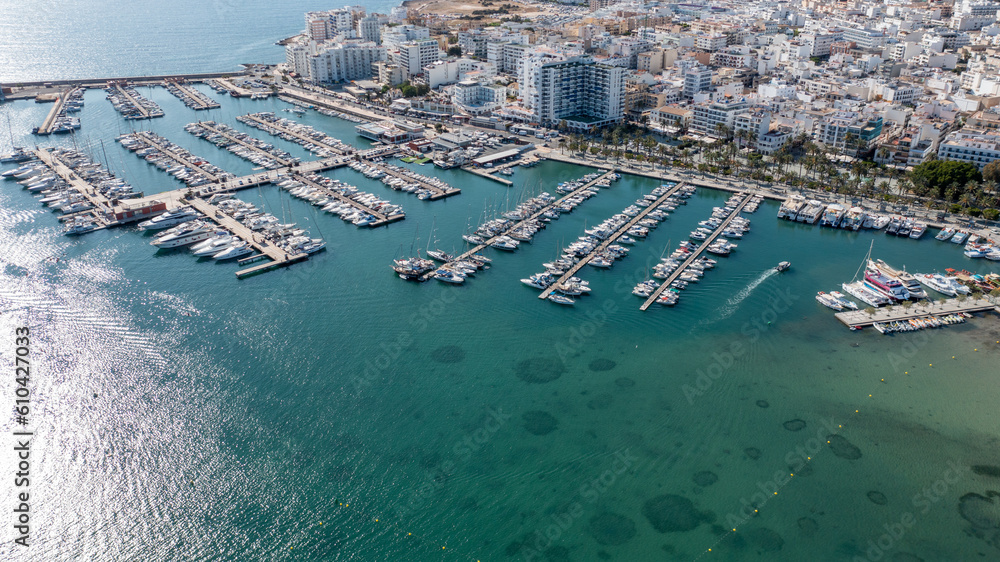 Aerial drone photo of the town of Sant Antoni on the island of Ibiza in the Balearic Islands Spain showing the boating harbour with parked up boats by costal front with hotels and apartments.
