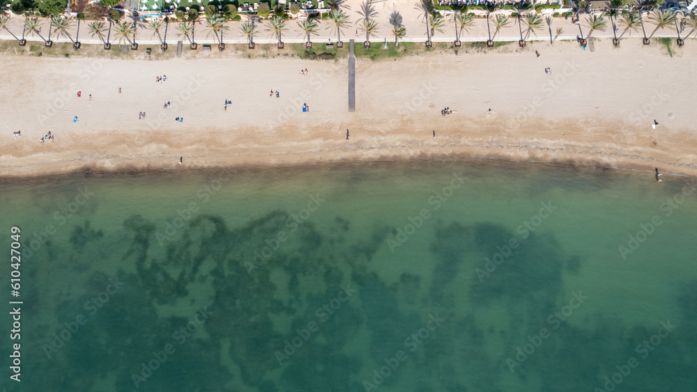 Straight down aerial drone photo in the beautiful town of Sant Antoni de Portmany in Ibiza Spain showing the beach known as Playa de San Antonio with people relaxing on the sandy beach in the summer