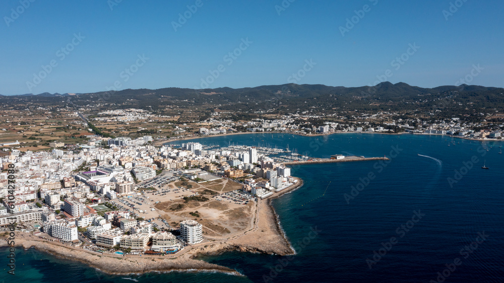 Aerial drone photo of a beach in the town of Sant Antoni de Portmany on the island of Ibiza in the Balearic Islands Spain showing the boating harbour and the beach known as Playa de San Antonio