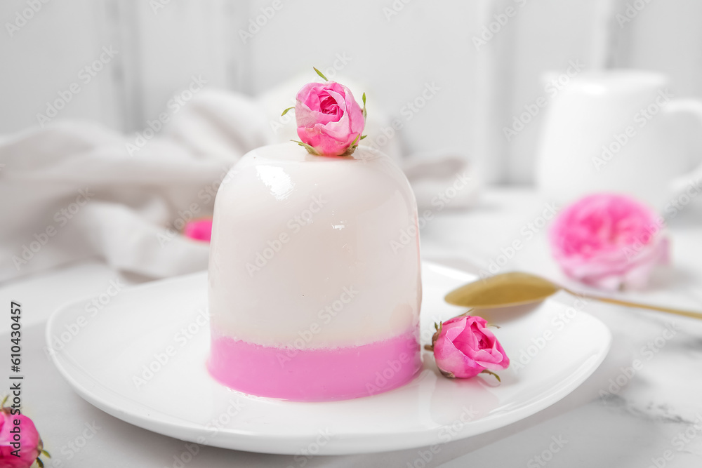 Plate of panna cotta with beautiful pink rose flowers on white table Plate of panna cotta with beautiful pink rose flowers on white table