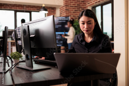 Freelance coder typing machine learning server code, sitting at desk table in it software company. Software developer working on database system with coding script in it developing office