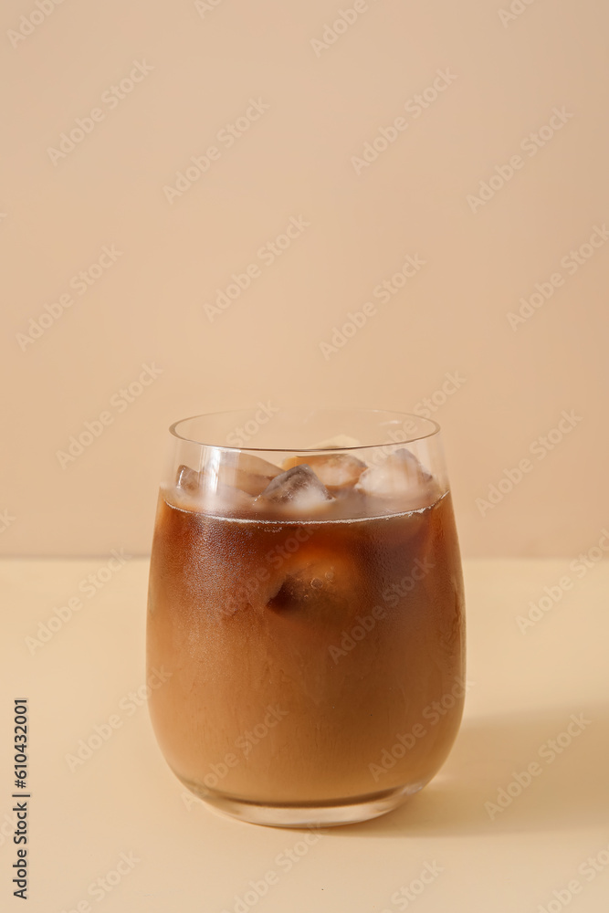 Glass with ice coffee on beige background Glass with ice coffee on beige background