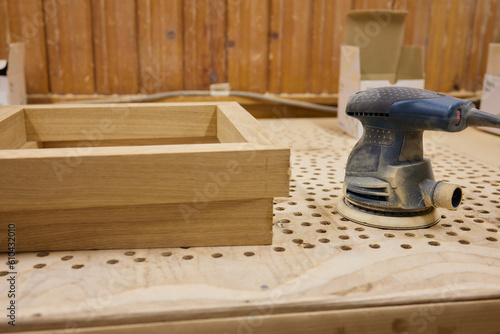 close up of a carpenter screwed a hinge on a wooden plank.