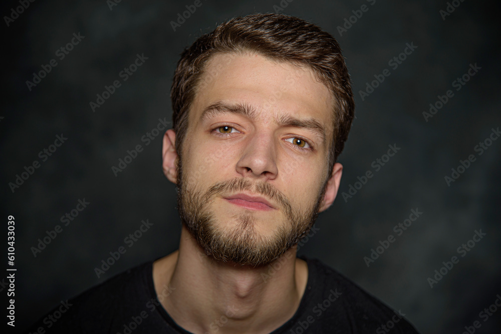 Portrait of an attractive young man with a beard on a dark background. Portrait of an attractive young man with a beard on a dark background.
