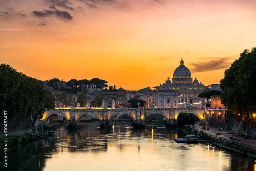 St. Peter's basilica across Tiber River canal at sunset in Rome, Italy