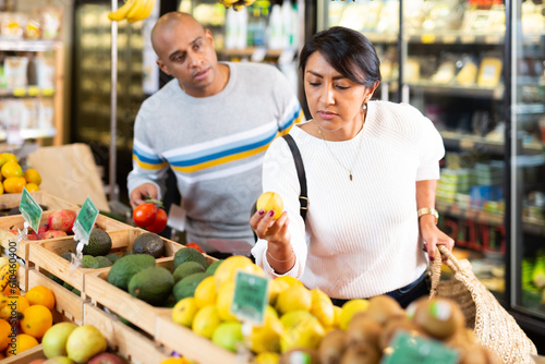 Married couple choosing fruits in grocery store