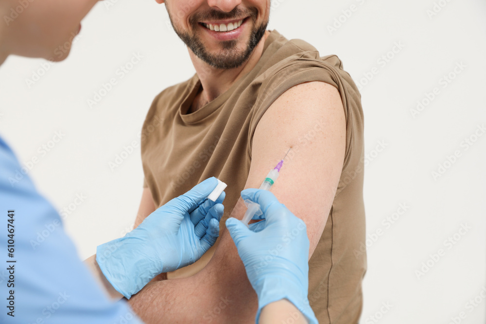Fototapeta premium Doctor giving hepatitis vaccine to patient on white background, closeup