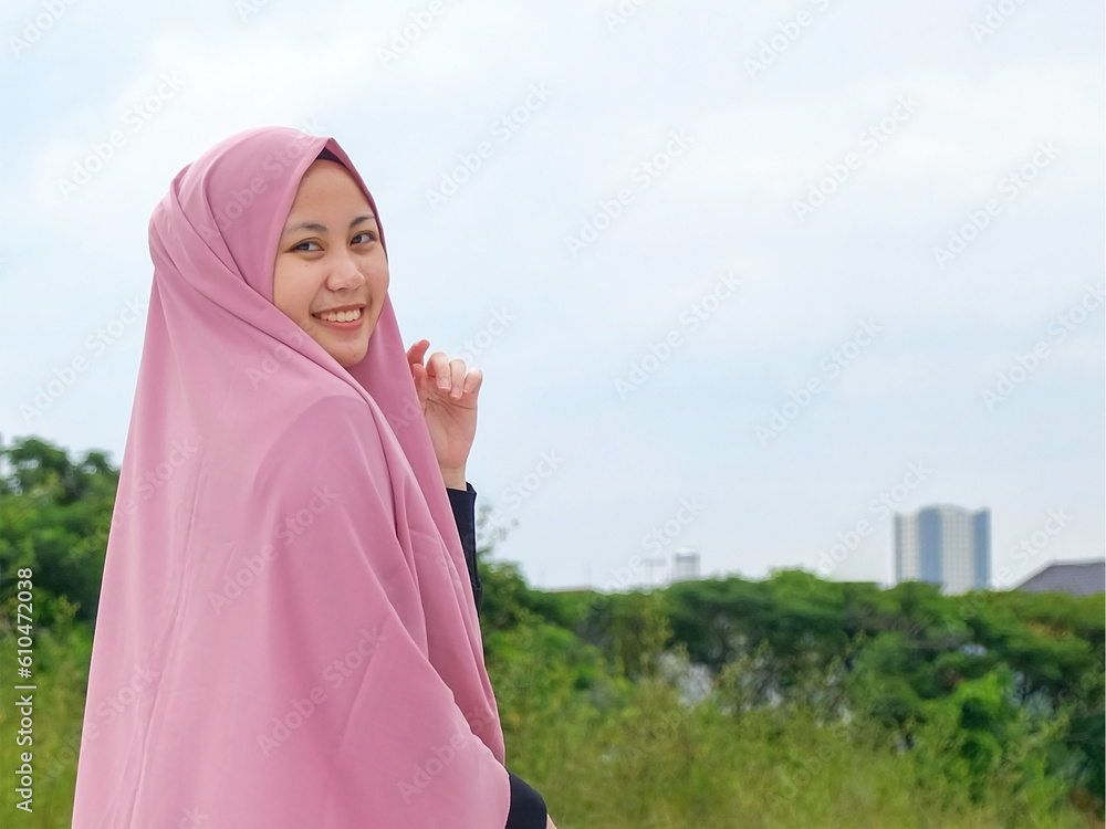 Asian Muslim woman smiles. Capturing the joy and grace that transcends cultural boundaries. Asian Muslim woman smiles. Capturing the joy and grace that transcends cultural boundaries.