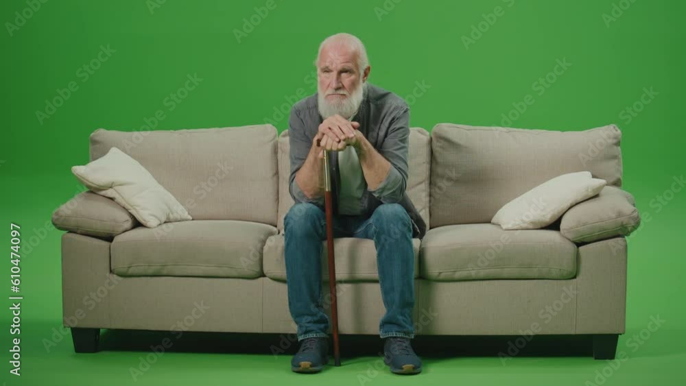 Green Screen. A Sad Old Man with a Stick Is Sitting On A Sofa. An Elderly Man Leaning His Head On A Stick and Rubs His Gray Beard. Mental Health for Seniors. Green Screen. A Sad Old Man with a Stick Is Sitting On A Sofa. An Elderly Man Leaning His Head On A Stick and Rubs His Gray Beard. Mental Health for Seniors.