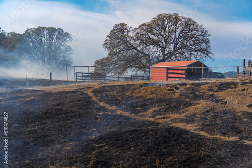 a metal barn that survived wildfire with smoke lingering