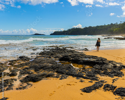 Female Tourist and Exposed Lava Reef, Kauapea Beach, Kauai, Hawaii, USA photo
