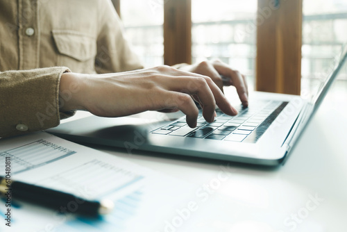 Close up of female hands while typing on laptop. photo