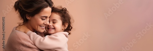 Portrait of a mother and child on pink background. Mom and baby embrace. Mother's Day. Loving parent.	