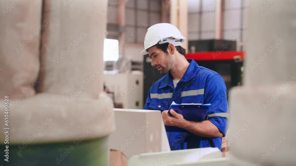 Professional Engineer man in safety uniform writing record data on clipboard and using Computer Numerical Control machine in warehouse at steel factory. Factory and warehouse concept Professional Engineer man in safety uniform writing record data on clipboard and using Computer Numerical Control machine in warehouse at steel factory. Factory and warehouse concept