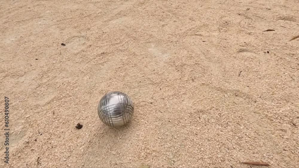 Metal Ball On Sandy Court Of Petanque Game - tracking shot Metal Ball On Sandy Court Of Petanque Game - tracking shot