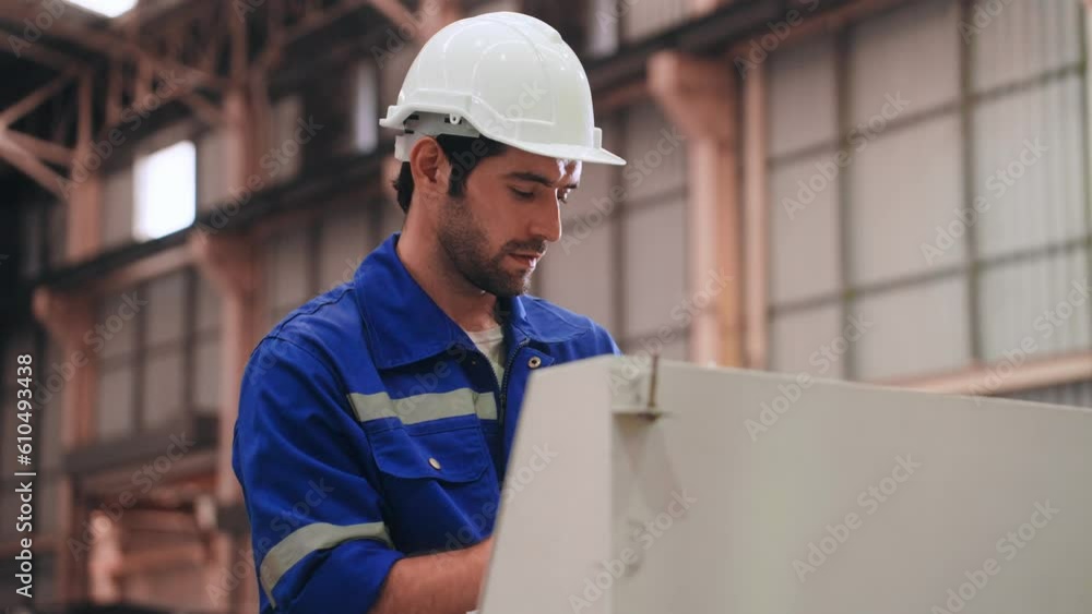 Professional Engineer man in safety uniform writing record data on clipboard and using Computer Numerical Control machine in warehouse at steel factory. Factory and warehouse concept Professional Engineer man in safety uniform writing record data on clipboard and using Computer Numerical Control machine in warehouse at steel factory. Factory and warehouse concept