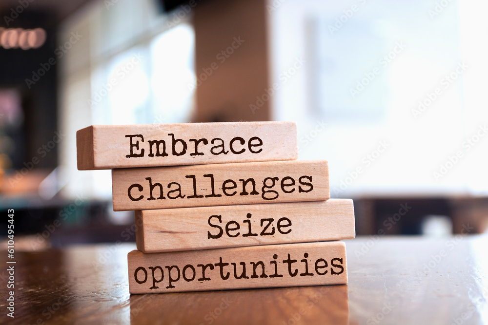 Wooden blocks with words 'Embrace challenges, seize opportunities'. Wooden blocks with words 'Embrace challenges, seize opportunities'.
