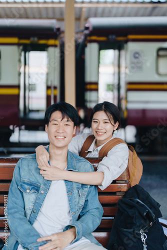 Tourist couples showing their love and happiness in a sweet way while waiting for their journey at the train station.