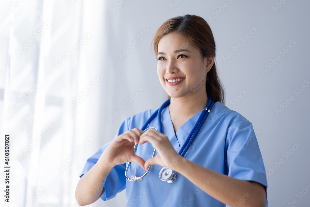 Happy doctor Portrait of young asian woman nurse or doctor smiling using a laptop writing content at consultation Happy doctor Portrait of young asian woman nurse or doctor smiling using a laptop writing content at consultation