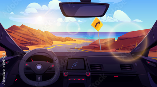 Inside car view on desert road to sea shore landscape. Turn sign on highway for direction drive to ocean beach coast. Steering control with navigation interface and windscreen scene on water and rock © klyaksun
