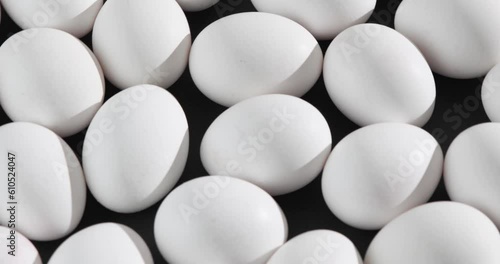 Eggs on a black background rotating in the light of the sun