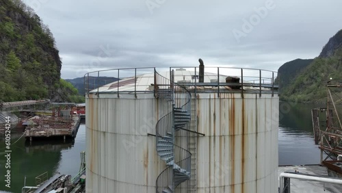 Industrial chemicals tank on quay in front of Osterfjorden in Eikefet Vikanes Norway - Rising aerial revealing fjord photo