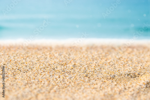 Close up of sand with blurred sea sky background, summer day, copy space.