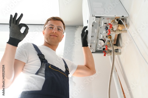 Professional boiler service: qualified technician checking a natural gas boiler at home photo